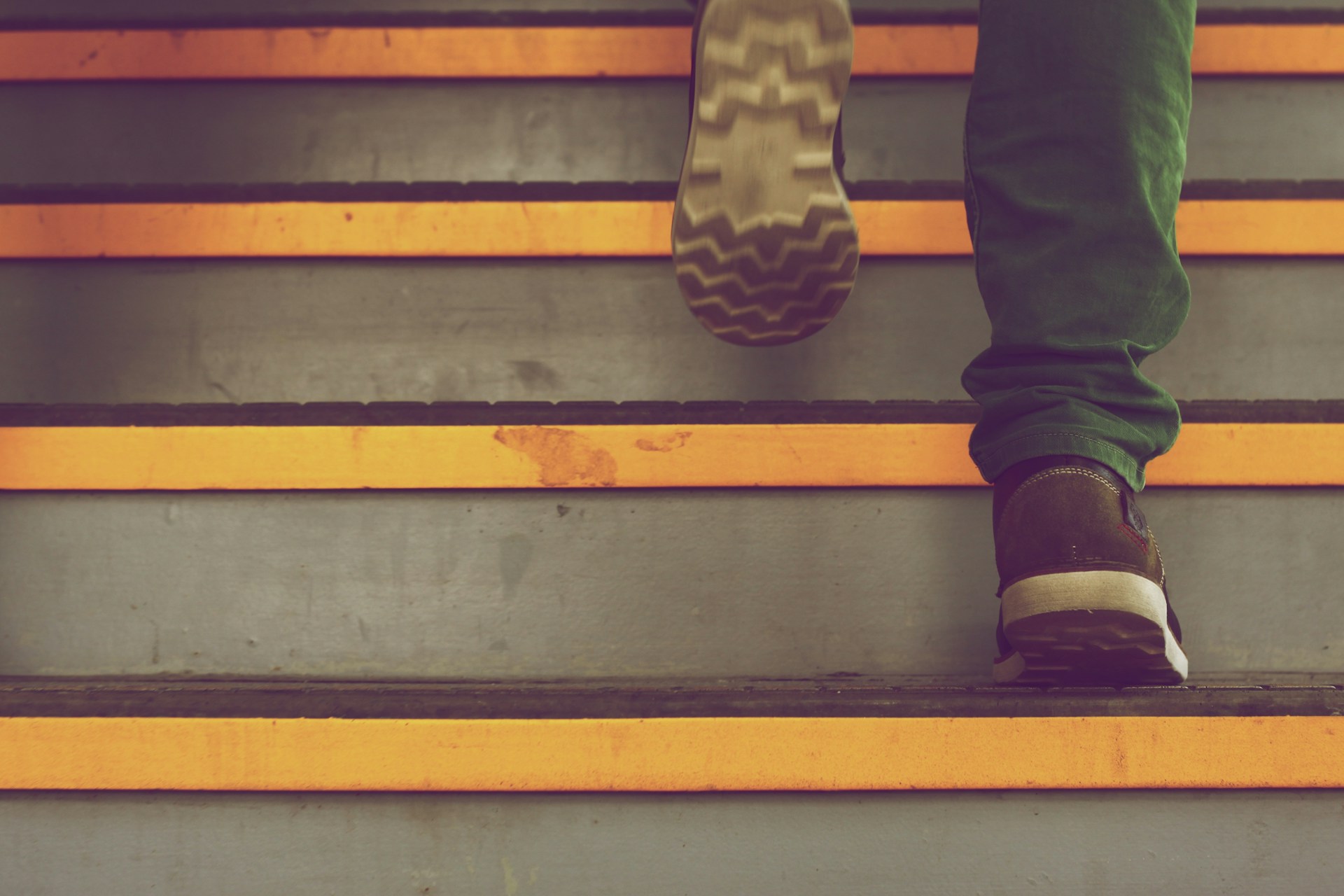 Person taking steps on colorful stairs - representing the power of one small step forward